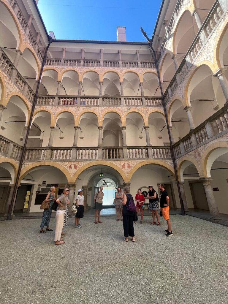 Mehrere Personen stehen im Innenhof von Schloss Hartheim.